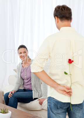 Passionate man hidden a rose behind his back for his grilfriend