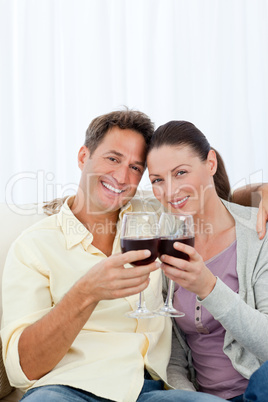 Lovely couple drinking red wine on the sofa