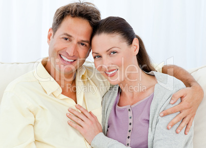 Portrait of a happy man and woman sitting on their sofa