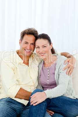 Lovely couple hugging sitting on the sofa