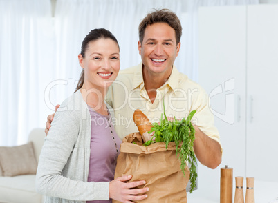 Portrait of a couple coming back from the market with vegetables