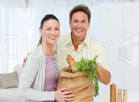 Portrait of a couple coming back from the market with vegetables