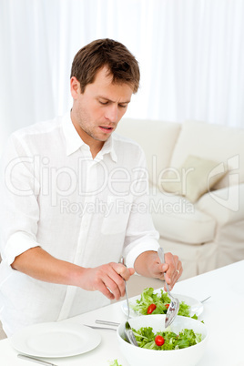Single man serving salad standing at a table