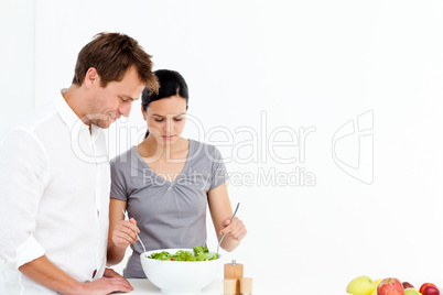 Active couple preparing a salad for lunch