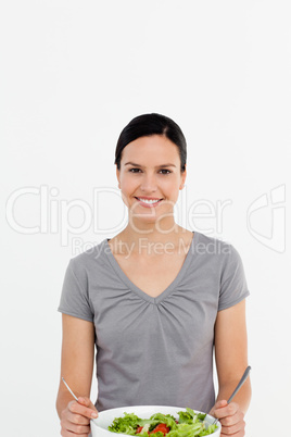 Portrait of a happy woman preparing a salad alone