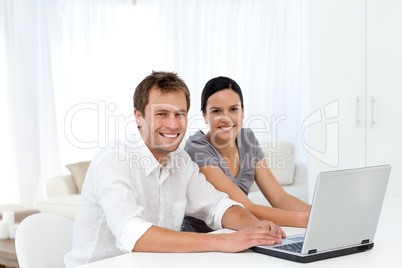 Portrait of a couple working on their laptop in the living room