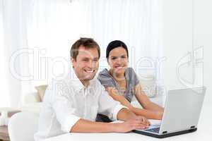 Portrait of a couple working on their laptop in the living room