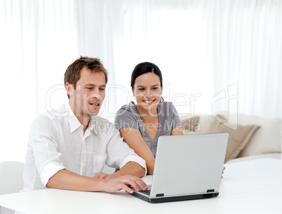 Happy man and woman looking at something on the laptop