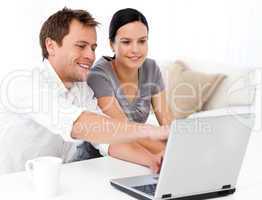 Cute man showing something on the laptop screen to his girlfrien