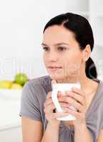 Quiet woman drinking her coffee in the kitchen