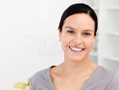 Cheerful woman standing in the kitchen