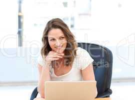 Happy businesswoman working on laptop at a table