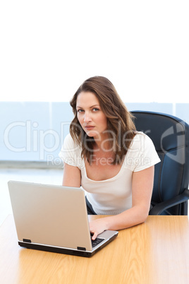 Portrait of a businesswoman working on laptop at a table