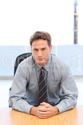 Confident manager posing alone at a table