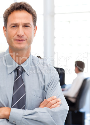 Assertive businessman standing in front of his team while workin