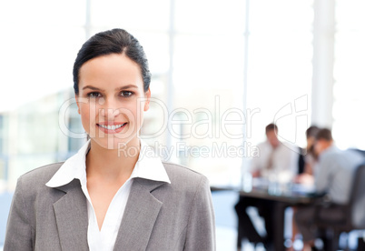 Adorable businesswoman standing in front of her team while worki