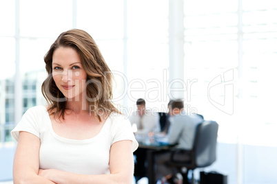 Beautiful businesswoman standing in front of her team while work