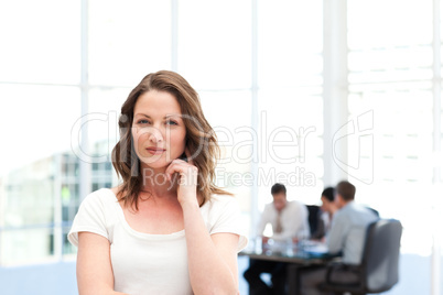 Pensive businesswoman standing in front of her team while workin