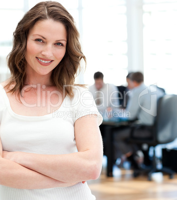 Happy businesswoman  posing in front of her team while working