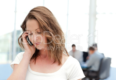 Businesswoman on the phone while her team is working