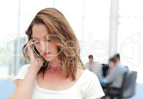 Businesswoman on the phone while her team is working