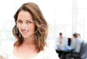 Relaxed businesswoman standing in front of her team while workin