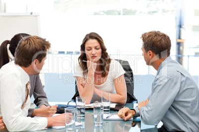 Thoughtful businesswoman at a table with her team
