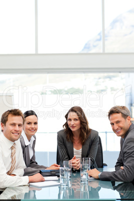 Confident businesswoman with herteam at a table