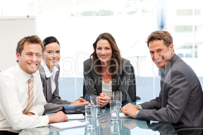 Portrait of a businesswoman with her team sitting at a table