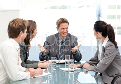Cheeful manager talking to his team at a meeting