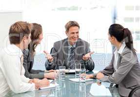 Cheeful manager talking to his team at a meeting