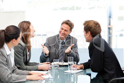 Happy team laughing together at a meeting