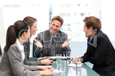 Delighted managertalking to his team at a table