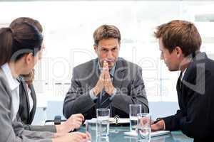 Serious manager talking to his team during a meeting