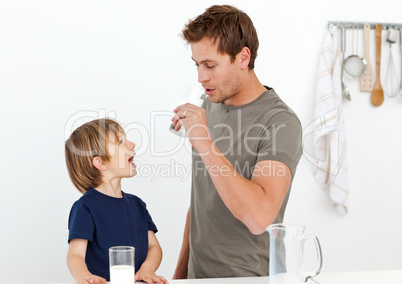 Happy dad and son drinking milk together