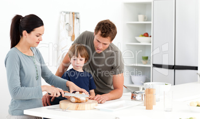 Lovely woman cutting bread for her son ad husband