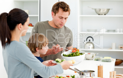 Dad serving salad to his family for lunch