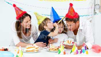 Happy family having fn while eating birthday cake
