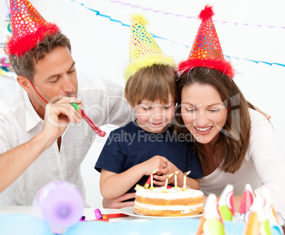 Happy family blowing candles together for a birthday