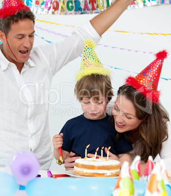 Cute boy blowing the candles on his birthday cake