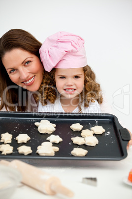 Happy mother and daughter holding a plate with biscuits