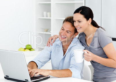 Affectionate woman looking at her boyfriend working on the lapto