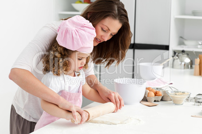 Mother and daughter using a rolling pin together