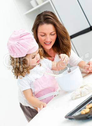 Little girl with her beautiful mother cooking together