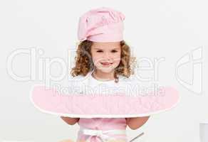 Little girl wearing kitchen gloves standing in the kitchen
