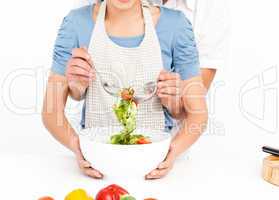 Close up of a man mixing a salad with his girlfriend