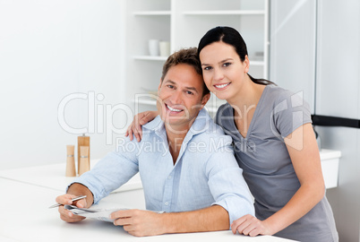 Portrait of a couple doing crossword together in the kitchen