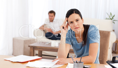 Worried woman doing her account while her boyfriend waiting in t