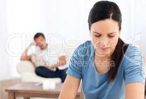 Woman thinking at a table while her boyfriend waiting