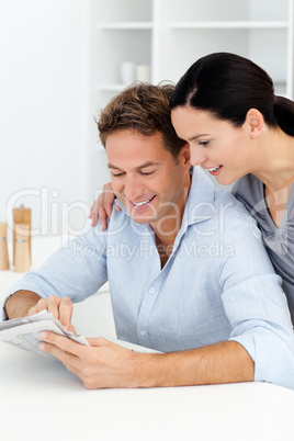 Lovely couple looking at something on the newspaper